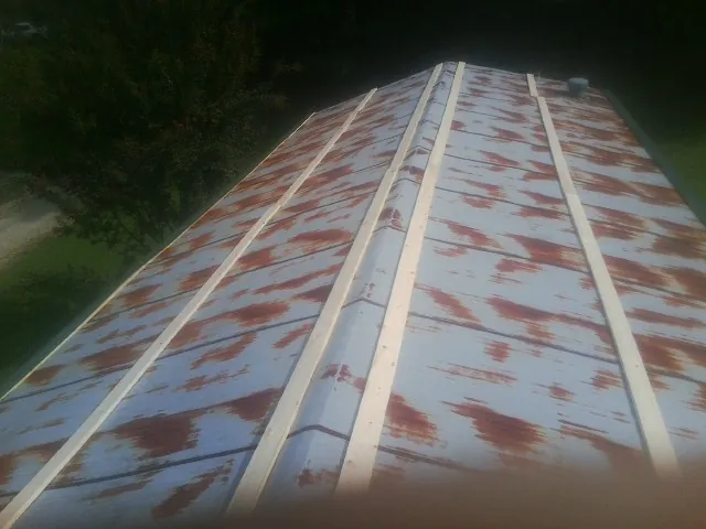 Rusted metal roof panels with new wood purlins before replacement — Storm Damage Roof Repair in Elco by Roofing Brothers