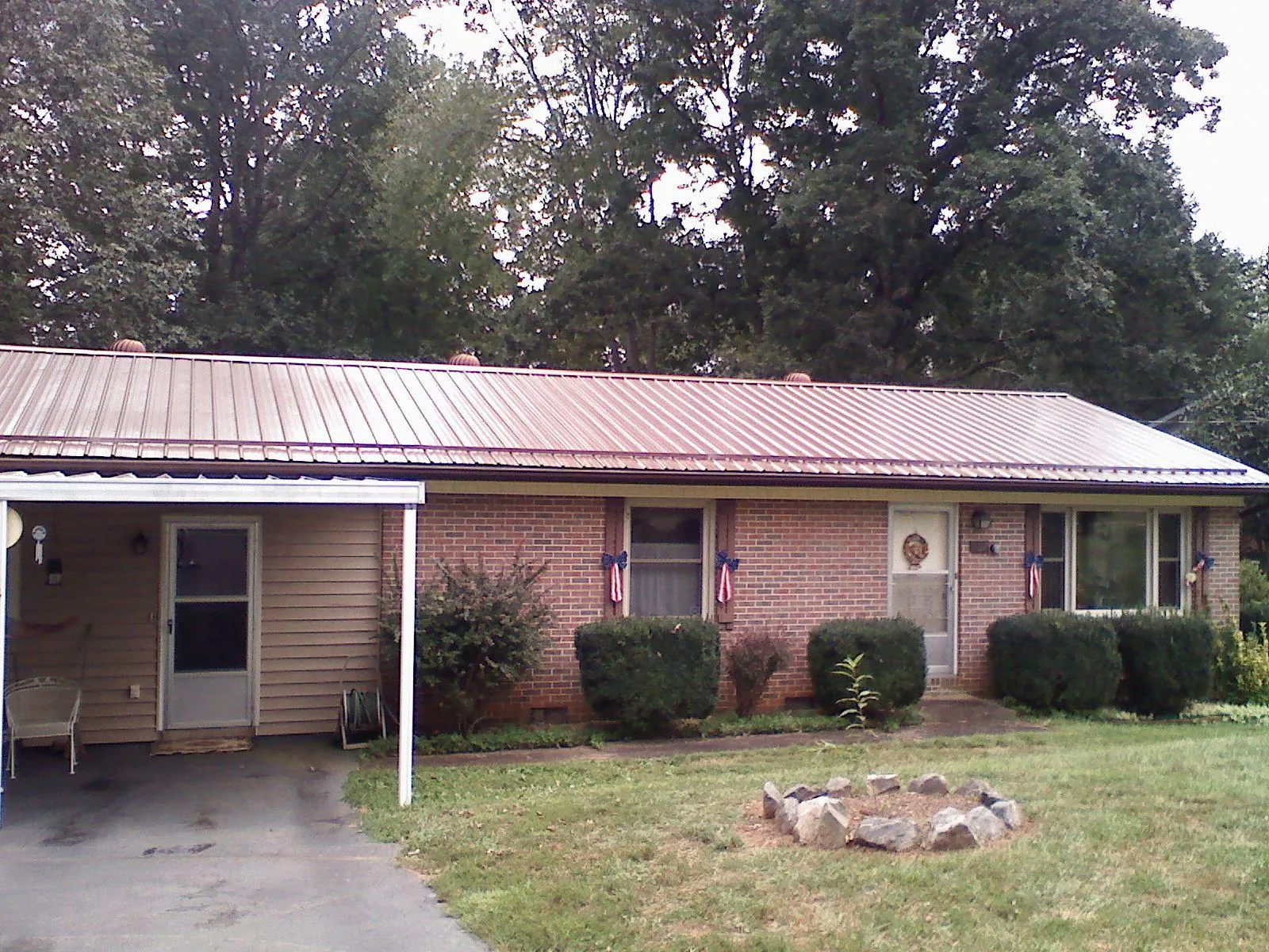 Bronze metal roof and carport on a brick ranch home — Roof Repair work by our crew in Elco